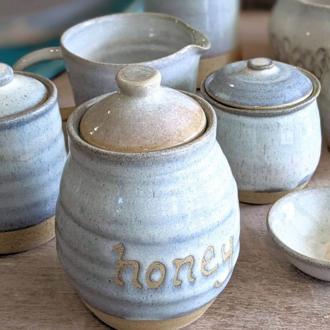 A collection of ceramic pots including a honey pot
